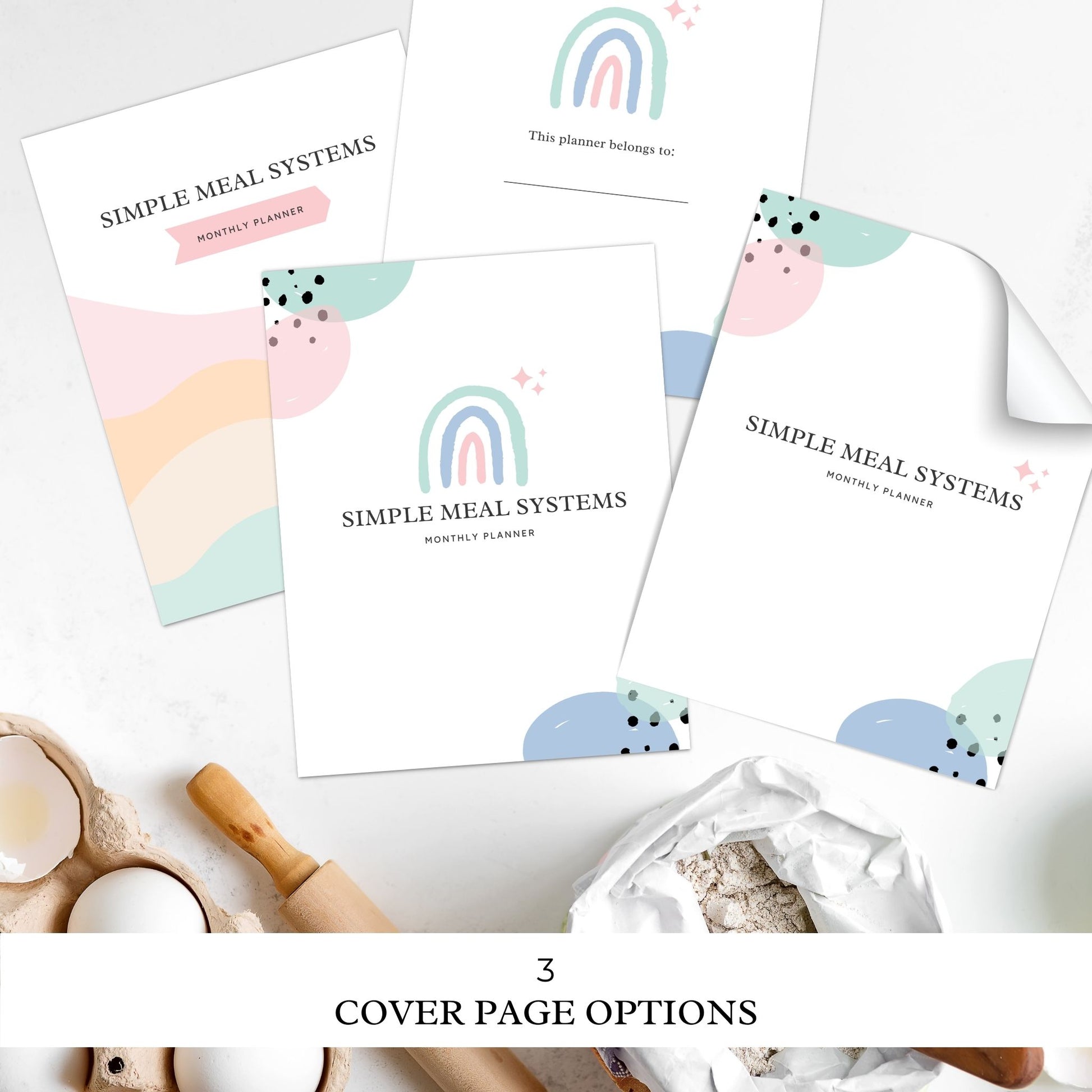 Mockup image featuring the simple meal systems meal planning binder printables cover page options laying on a kitchen counter beside a pencil. A carton of eggs, a rolling pin and a bag of flour in background of image. Text on image reads 3 cover page options.