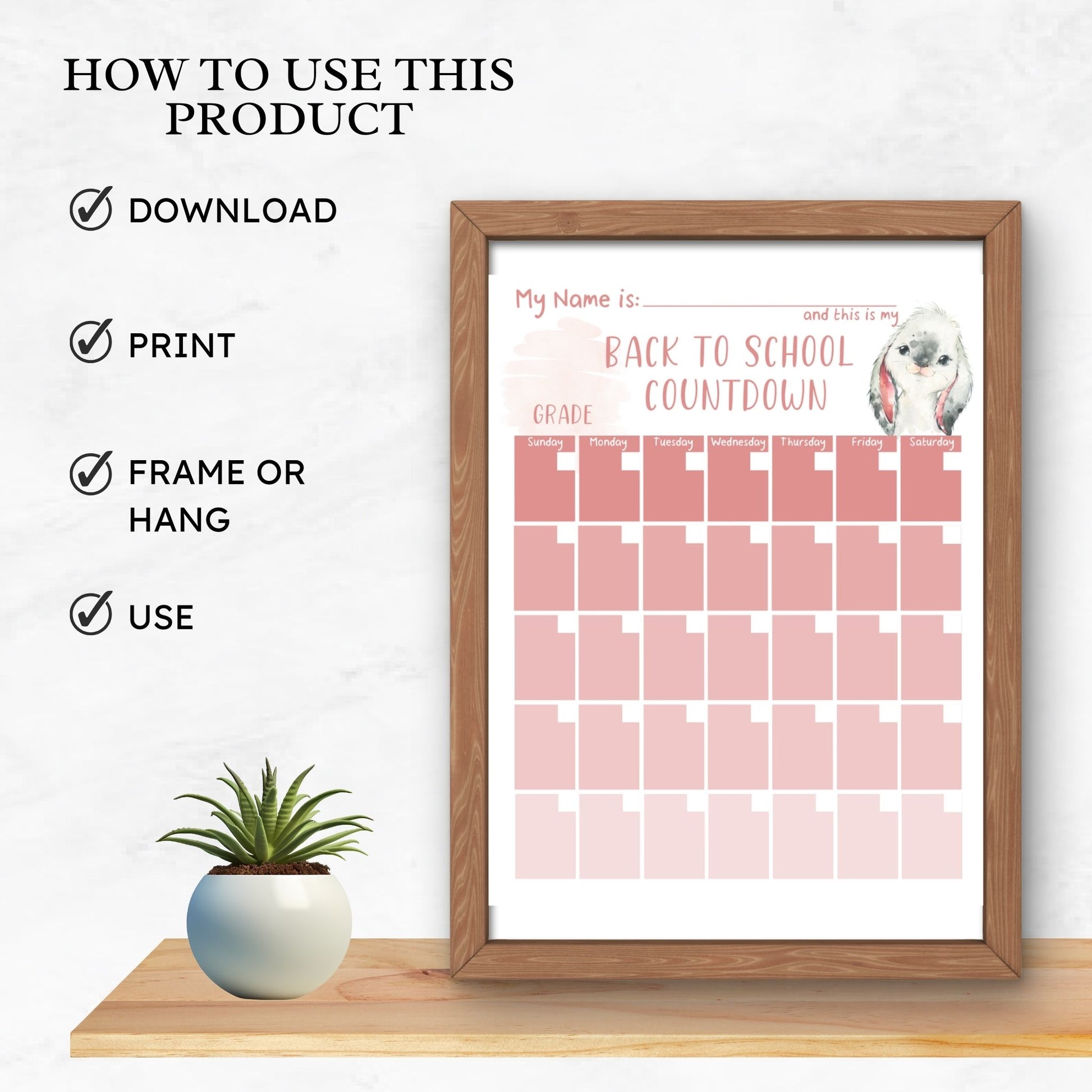 wooden frame on a shelf with a plant sitting beside. Text on image states how to use this product. Download, print, frame or hang and use. Picture in frame is a mockup image of the countdown printchool calendar countdown for back to school in the pink ombre calendar grid with watercolour bunny design